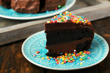 Chocolate cake with colorful sweet powder on table close-up