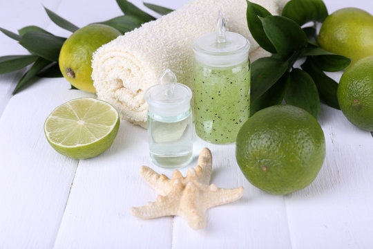 Spa composition with lime and towel color wooden background