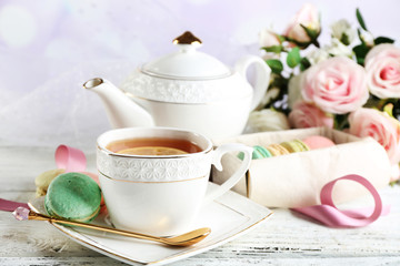 Colorful macaroons with cup of tea
