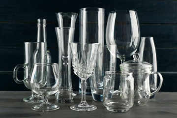 Different glassware on dark color wooden background