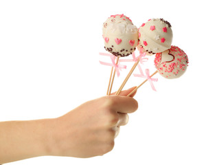 Female hand holding cake pops, isolated on white