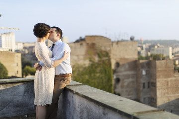 Fototapeta na wymiar Newlyweds kissing on the rooftop