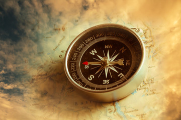 Compass with dramatic sky background.