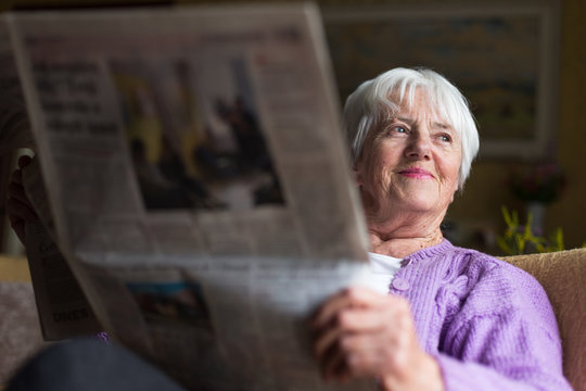 Senior woman reading morning newspaper