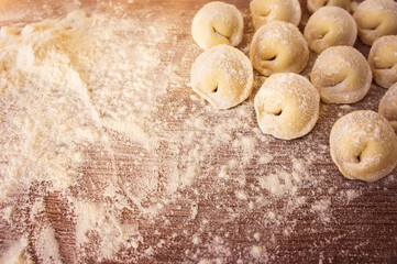 Top view on homemade pasta ravioli over wooden table with flour