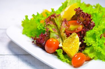 Disk of salad on wooden white table