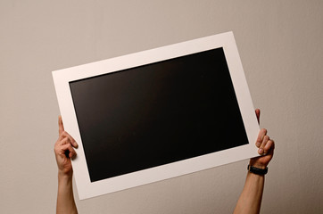 Hände halten eine leere Tafel hoch