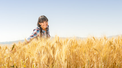 Smiling beautiful young brazilian girl on a yellow crop field