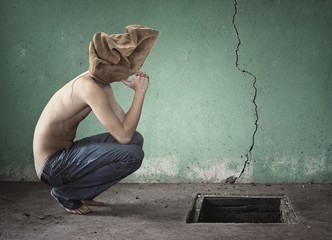 Surreal image with bag over his head shirtless and blue jeans