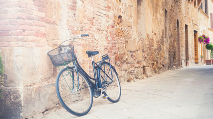 Fototapeta na wymiar Black vintage bicycle left on a street in Tuscany, Italy
