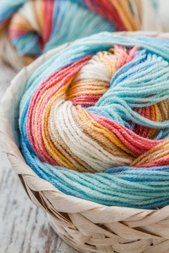 Colorful Soft woolen yarns in a Basket on wooden background	