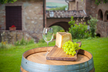 Cheese and grapes on a barrel in the Tuscan landscape Italy