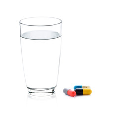 glass of water and pills capsules isolated on white background