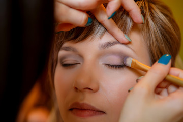 makeup artist doing makeup bride