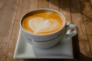 cup of cappucchino over wooden table