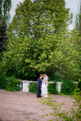 the bride and groom walk in the park