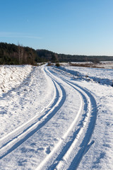 snowy winter road with tire markings