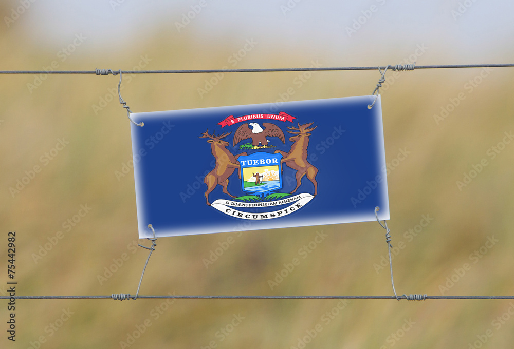 Wall mural border fence - old plastic sign with a flag