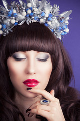 beautiful young woman wearing designer wreath and posing against