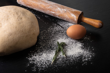 Flour, rolling pin, egg, rosemary and dough for pie