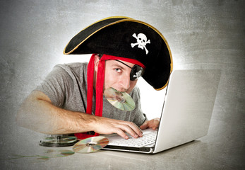 man in pirate hat downloading music files and movies on computer