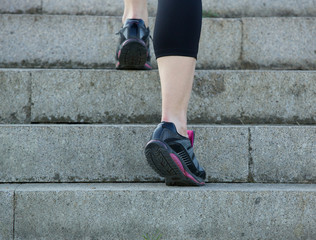 Fototapeta na wymiar Young sport woman walking upstairs in gym shoes