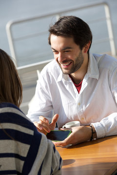 Young man smiling and showing woman mobile phone