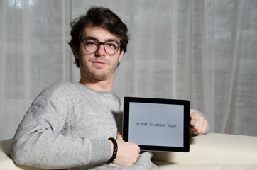 Junger Mann mit Nachricht Komm in unser Team auf Tablet