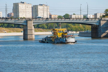 Urban landscape with river, bridge and boat