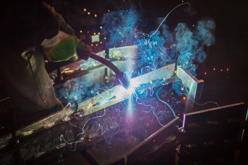 Flash of smoke and colorful sparks during welding - obrazy, fototapety, plakaty