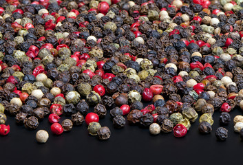 Red, black, green and white peppercorns