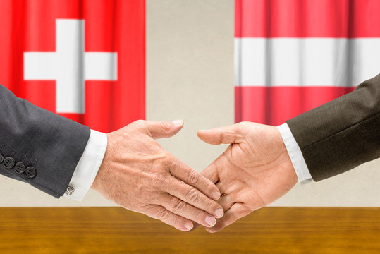 Vertreter der Schweiz und Österreichs reichen sich die Hand