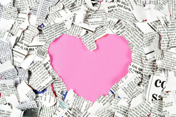 Pink heart shape and shredded newspaper pieces.
