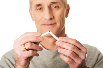 Portrait of mature man breaking cigarette