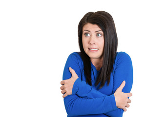 Scared young woman hugging herself 