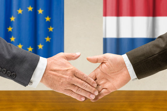 Vertreter der EU und der Niederlande reichen sich die Hand