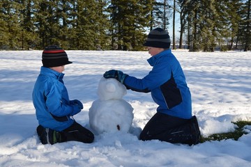 Kinder bauen Schneemann