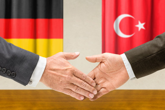 Vertreter Deutschlands und der Türkei reichen sich die Hand
