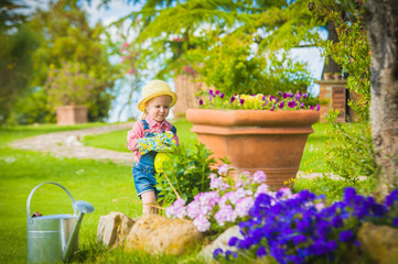 Little girl helping her mother in the garden