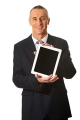 Happy mature businessman holding digital tablet