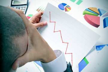 businessman observing a chart with a downward trend