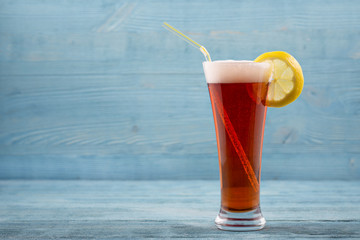 Glass of beer with lemon and sipper