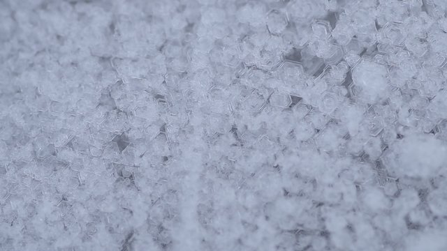 Frozen water crystals and snow begins to fall
