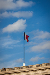 Flag of France fluttering under a serene blue sky