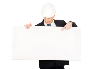 Businessman with hard hat holding empty banner