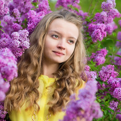 Fototapeta premium Spring portrait of a beautiful girl with lilac