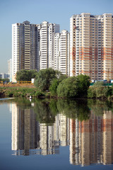 Many block of flats over river and clear blue sky