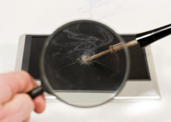 Soldering iron with tablet through a magnifying glass