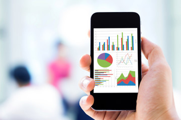 hand holding mobile phone with analyzing graph