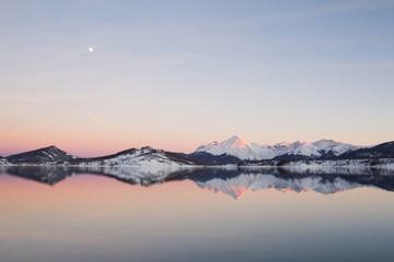 Fototapeta na wymiar Riflessi delle montagne sul lago al tramonto